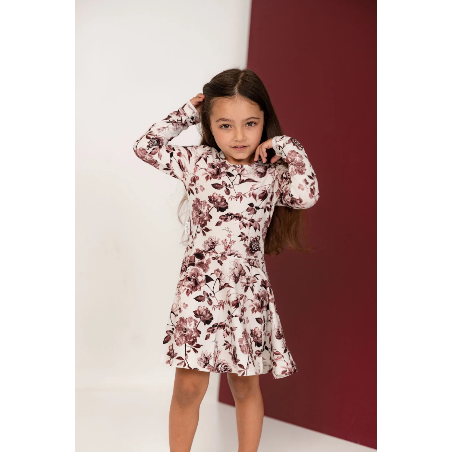 Tyttö katsoo kameraan päällään kaunis kukka kuosillinen mekko A-helmaisella hameella