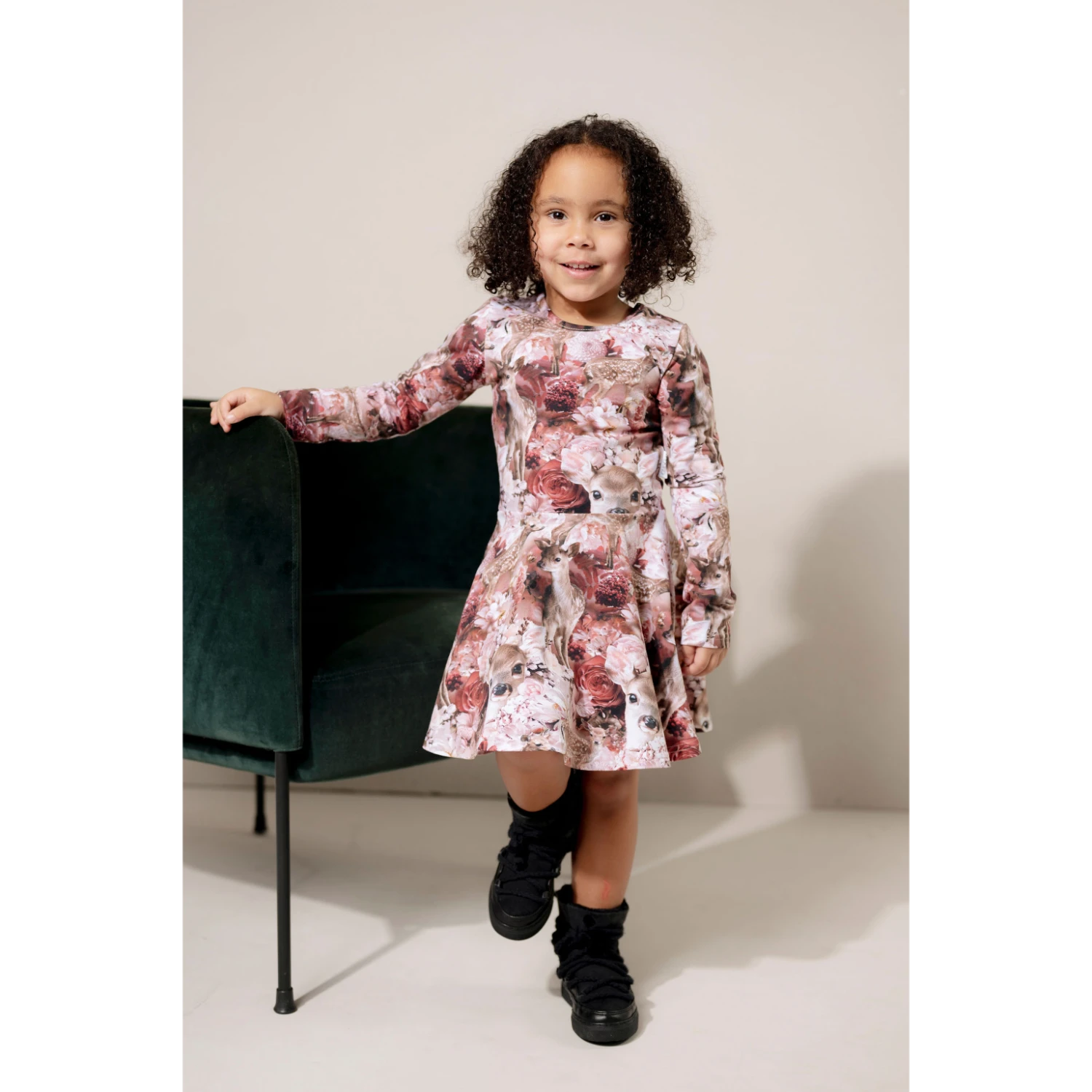 Tyttö katsoo kameraan päällään kaunis kukka bambi kuosillinen mekko