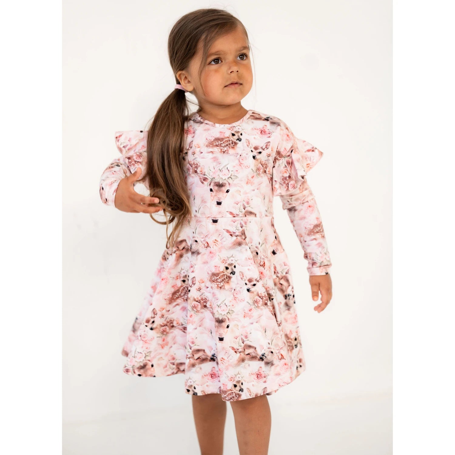 [ALL] Lapsi poseeraa vaaleanpunaisessa mekossa, jossa on upea Bambi-kuosi ja röyhelöhihat – täydellinen yhdistelmä suloisuutta ja tyyliä